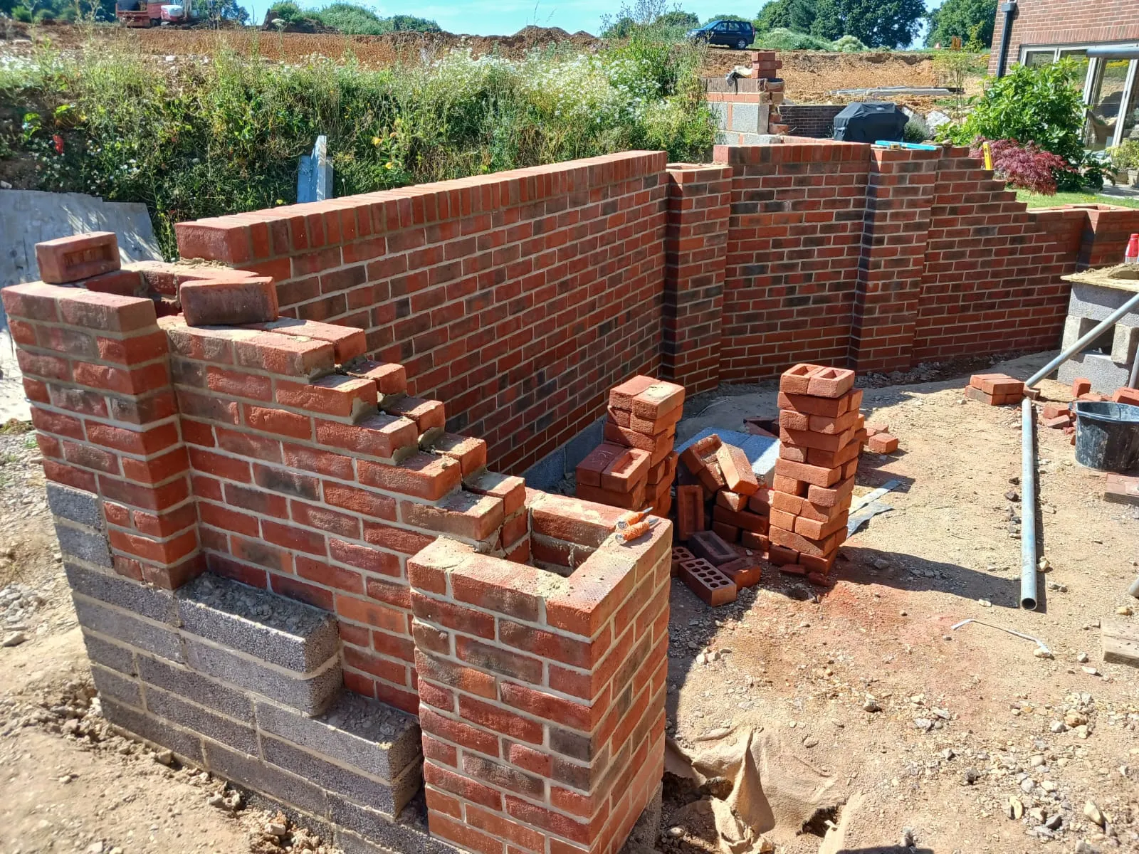 A brick wall being built in a yard.